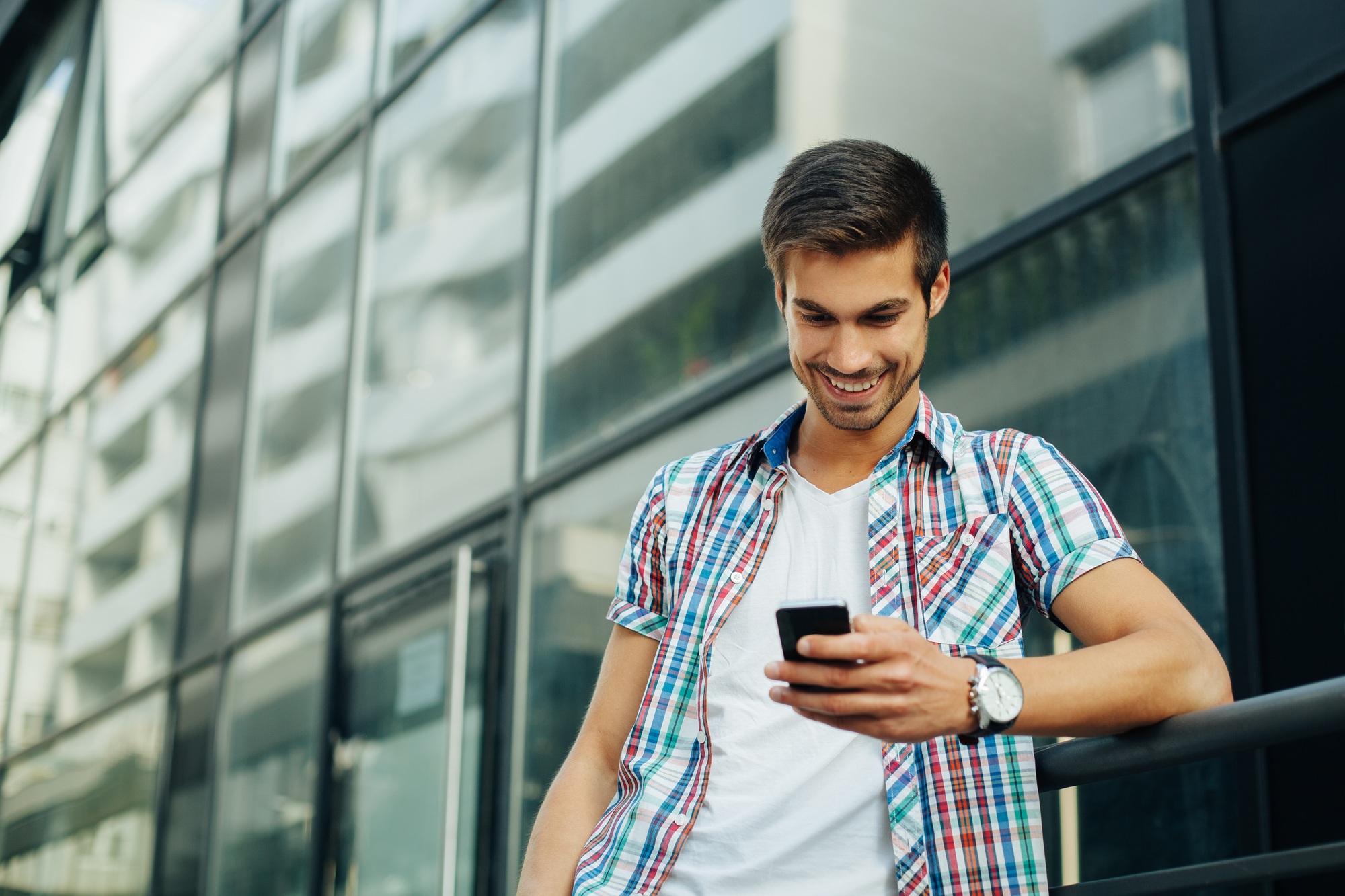 Handsome man typing text message on the phone