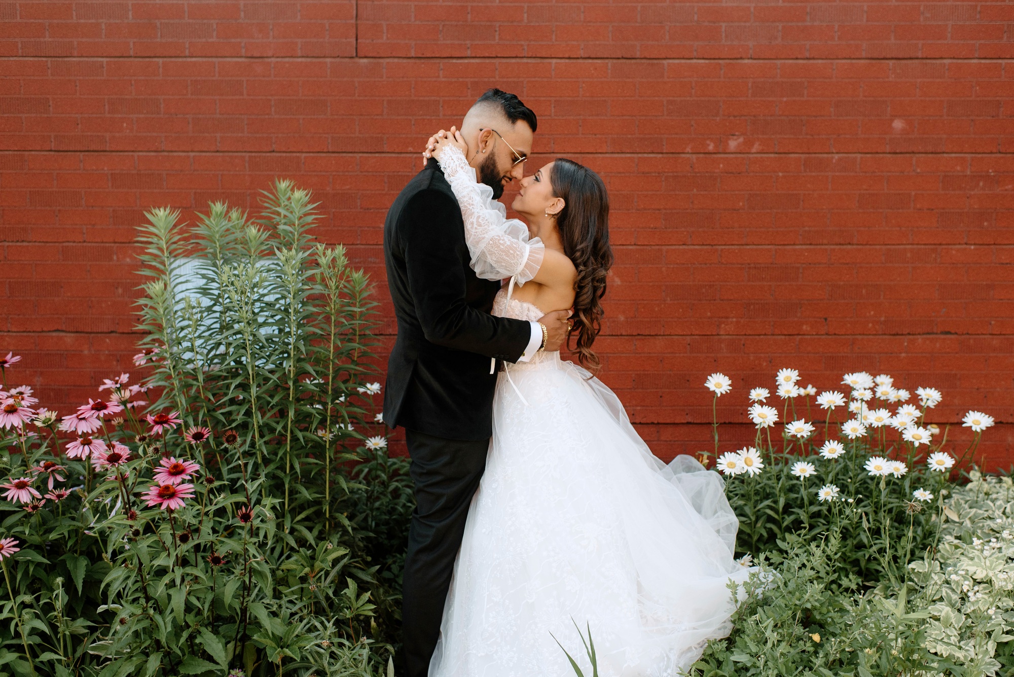Wedding bliss against a brick wall backdrop